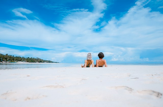 Dve osobe se sunčaju na plaži